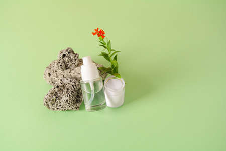 Cosmetics bottle with gel or other cosmetic product, stones and flowerの写真素材