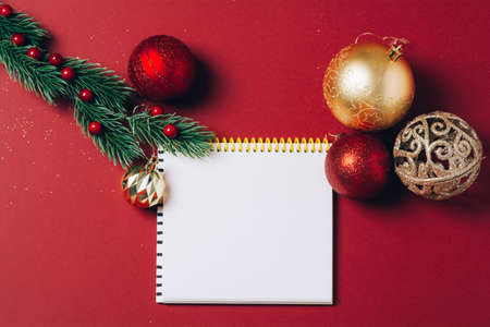 Christmas holiday decorations and notebook on red background.の写真素材