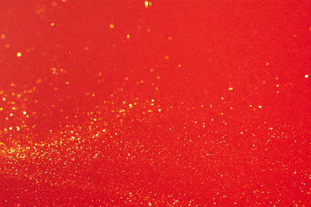 Small gold glitter on bright red backgroundの写真素材