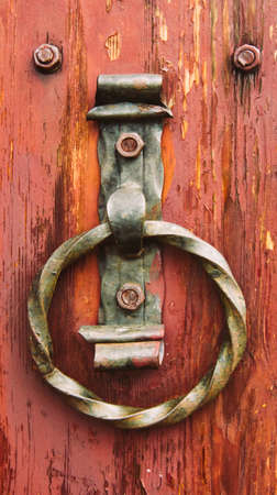 Old wooden door with rusty doorhandle. Ancient traditions in architecture