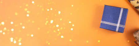 Banner. Preparing for the men's holiday. Blue gift boxes, paper's rools and rope on orange backgruond. Flat lay and copy space.の写真素材