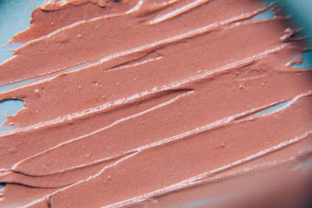 The texture of the foundation is beige under the make-up on a blue background.の写真素材