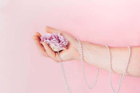Pink flower, rose in a man's hand. Male beauty and health concept, selfcare trendの写真素材