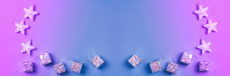 Banner. Christmas toys white stars with sparkles and silver gifts on a blue and violet background. Toned image. Holidays and Christmas concept.の写真素材