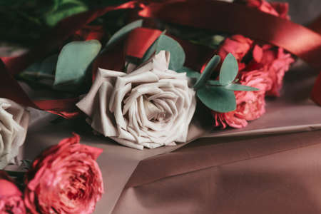 Pink roses on brown paper with ribbon. Preparing a bouquet for the holiday. Copy spaceの写真素材