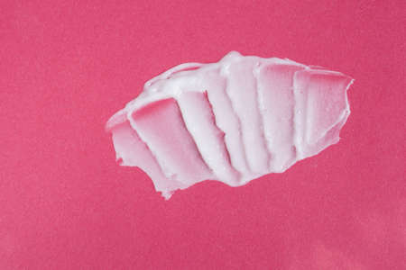 Smear of white face cream on pink background. Cosmetic product textureの写真素材