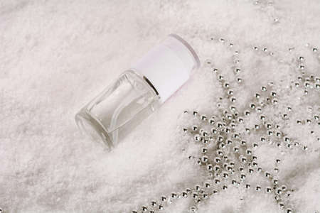 Facial cosmetic product in the snow with christmas decoration. Liquid skin or hair care product....