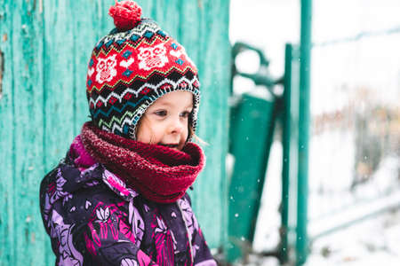 Happy and cheerful child outdoors in winter on the background of nature. Child portrait looking to the sideの写真素材