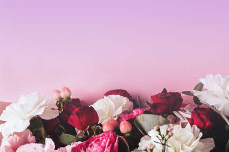 Beautiful spring flowers on a gradient violet background. Layout with space for textの写真素材