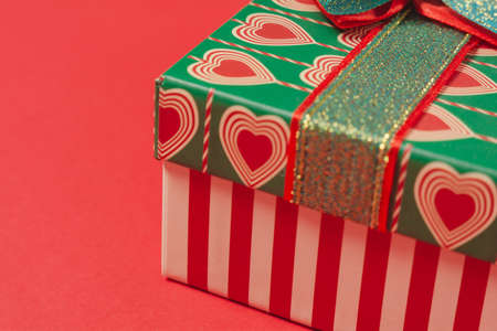 Gift box with hearts on a red background. Background for the holiday of Valentine's Day. The concept of love, romance and tendernessの写真素材