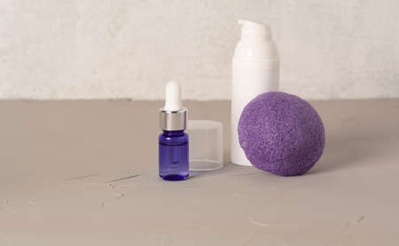 Beauty, spa and wellness concept. Facial cosmetic products, konjac sponge on gray texture background. front viewの写真素材
