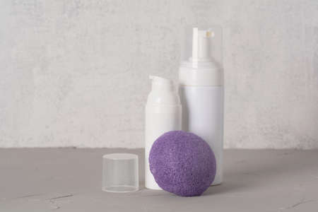 Beauty, spa and wellness concept. Facial cosmetic products, konjac sponge on gray texture background. front viewの写真素材