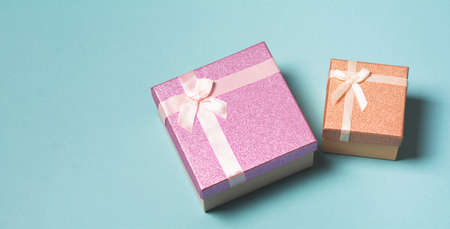 Violet and beige gift box on a blue background. Birthday, mother's or valentine's day gift. Holiday and generosity concept. copy spaceの写真素材