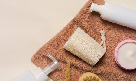 Spa cosmetic products and eco friendly bathroom accessories on a beige background. Beauty, spa and wellness concept. Flat lay composition, copy spaceの写真素材