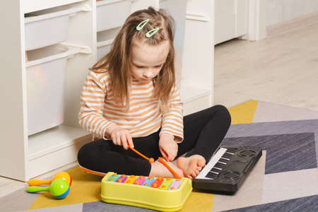 Child at home learning to play musical instruments. Leisure and education at homeの写真素材