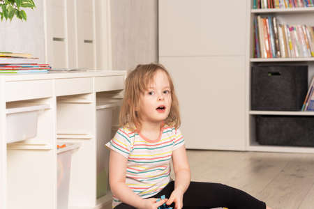 Child playing on the floor in dinosaurs in the room. development in the game. Leisure and education at homeの写真素材