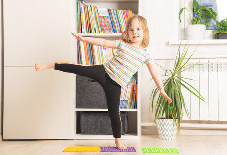 The child trains at home: fitness, yoga, exercises. Distant training with personal trainer, social distance, online education concept. Physical and mental health trendsの写真素材