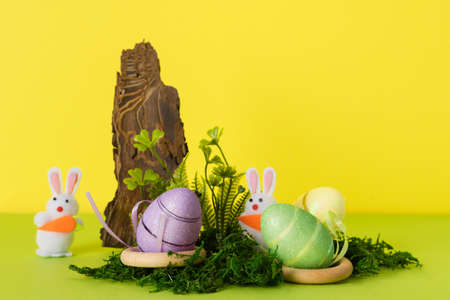 Easter composition with decorative rabbits and eggs in the nest with natural moss and wood. Background for your project for the holiday happy easterの写真素材