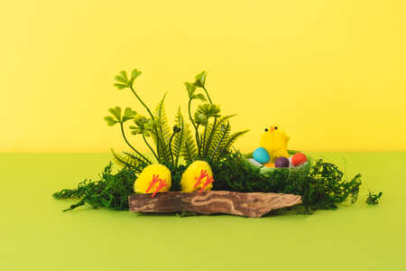 Easter composition with decorative yellow chickens and eggs in the nest with natural materials. Background for your project for the holiday happy easterの写真素材