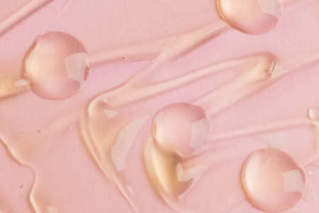Liquid gel texture closeup on pink background. cosmetic product textureの写真素材