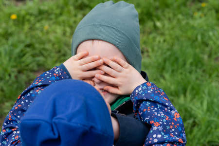 Two children covered each others eyes with their handsの写真素材
