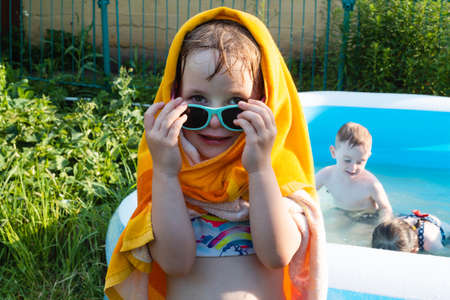 Wet child in a towel near the poolの写真素材