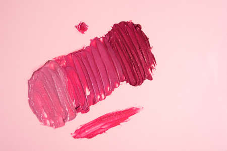 Swatches of shimmery shades of red and pink lipstick. Texture of decorative cosmeticsの写真素材
