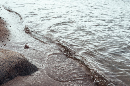 Sandy shore with cold bay waves. Copy spaceの写真素材