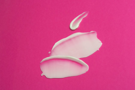 White cosmetic product on pink background
