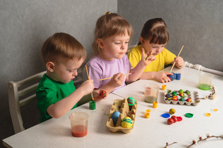 Children color eggs with food coloring. Brother and sisters painting Easter eggs.の写真素材