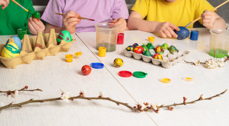Children's hands that paint quail eggs for Easter. Preparing for a happy easter holidayの写真素材