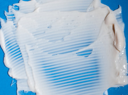 Smear of a white cream cosmetic product on a blue background.の写真素材