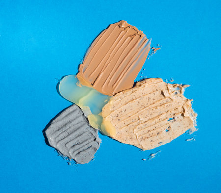Different swatches of cosmetic products for the face and body on blue background. Texture of skin care cosmetic product.の写真素材