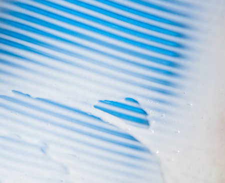 Smear of a white cream cosmetic product on blue background. Texture of cosmetic cream.の写真素材