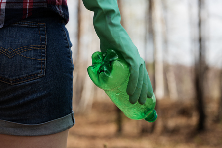 woman picking up dump on dirty forestの写真素材