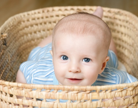 happe little boy is lying in basket の写真素材