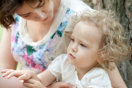 Girl of three years with her mother outdoorsの写真素材
