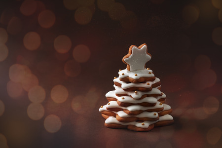 christmas spice cake in the form of fir on the brown background with bokehの写真素材