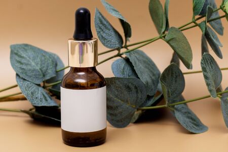Serum, essential oils or fluid collagen in brown glass bottle with pipette, isolated on brown backgraund, empty label, copyspaceの写真素材