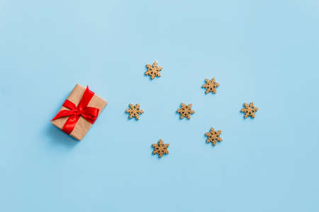 Christmas gift box tied with a red ribbon on a blue background with Golden snowflakes, Christmas and...