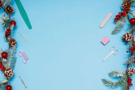 manicure set with two spruce branches decorated with balls on a blue background. preparing for a...