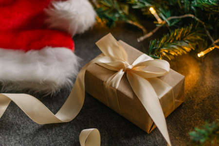 Christmas gift with Santa Claus hat and Christmas decorations on gray background with Christmas lights.の写真素材