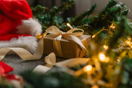 Christmas gift with Santa Claus hat and Christmas decorations on gray background with Christmas lights.の写真素材