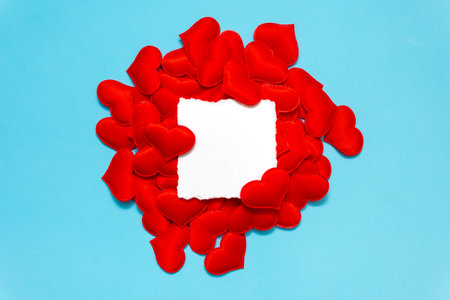 Creative layout of red hearts on a blue background. Minimal valentine's day greeting card with copy space. Border arrangement backgroundの写真素材