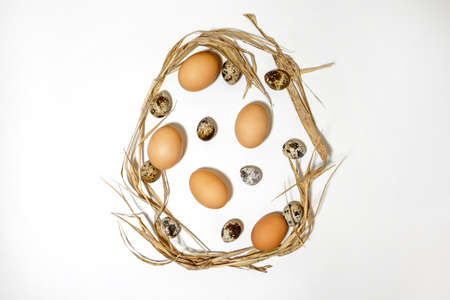 The Easter egg shape is made of eggs and straw. Minimal holiday concept. Flat ley, top view. ...