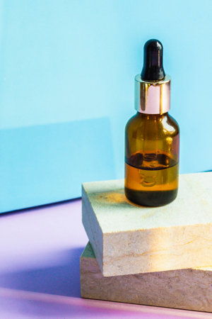 A cosmetic jar with an eyedropper stands on two granite slabs like on catwalks. The concept of minimalism and environmental friendliness.の写真素材