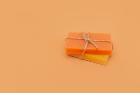 Bars of peach and apricot hard soap, tied with string on a beige background. Eco-friendly natural handmade cosmetics.の写真素材