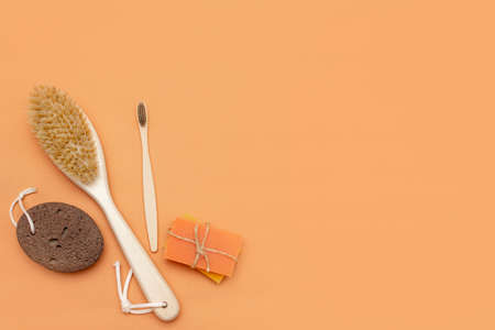 Bathroom accessories with zero waste, natural bristle brush, wooden toothbrush, bars of solid soap, natural pumice stone for pedicure on a beige background.の写真素材