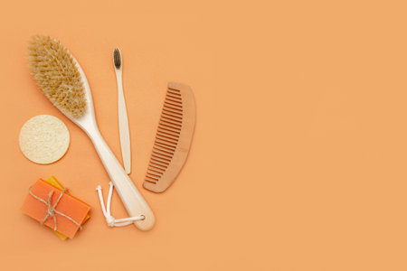 Bathroom accessories with zero waste, natural bristle brush, wooden toothbrush, bars of solid soap, wooden comb, with a palm leaf on a beige background.の写真素材