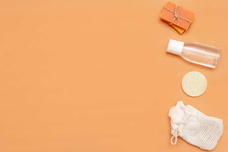 Bathroom accessories with zero waste sponge, bars of solid soap, cosmetic bottle on a beige background.の写真素材